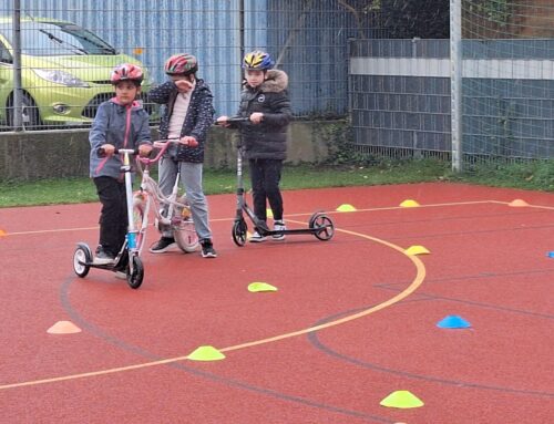 Kinder fahren mit ihren Rollern den aufgebauten Parcour