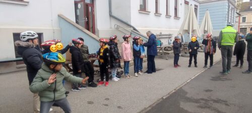 Kinder setzen den Fahrradhelm mit Hilfe von Erwachsenen richtig auf