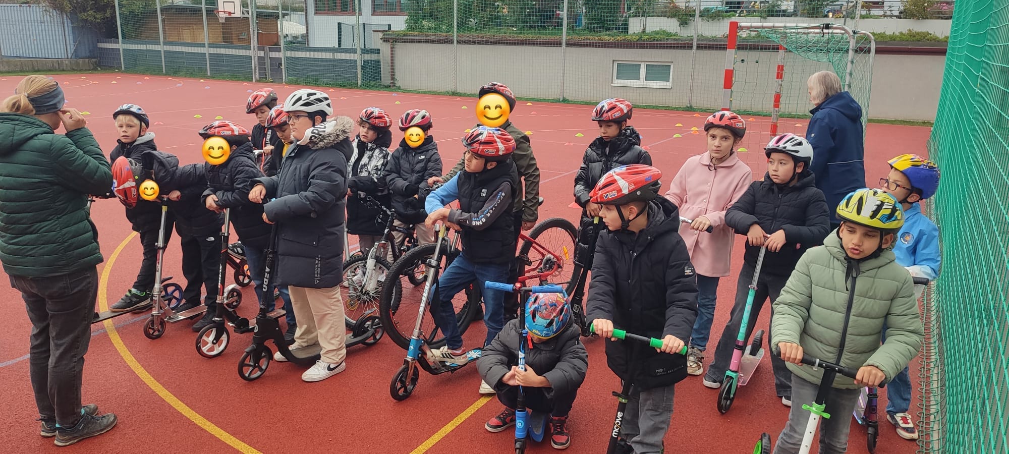 Kinder stehen mit ihren Rollern und Fahrrädern beisammen