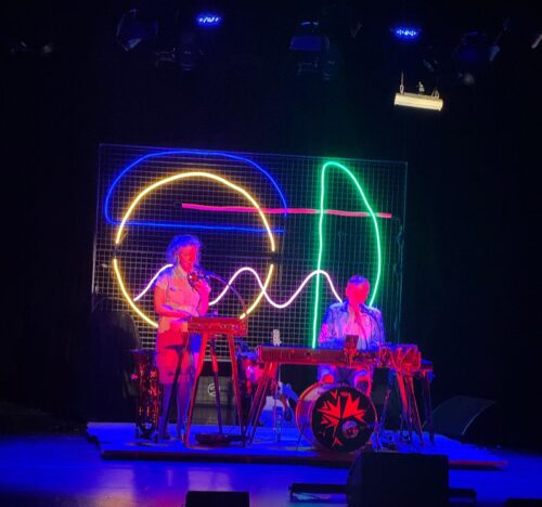 Zwei Künstler mit Instrumenten und Neonlichtern