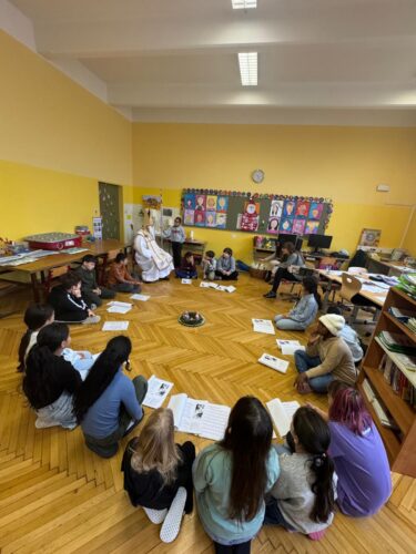 Die Kinder sitzen im Sitzkreis. Der Nikolaus ist auch dabei. 