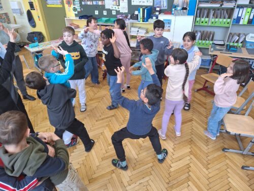 Kinder stehen im Kreis und stellen verschiedene Gefühle dar