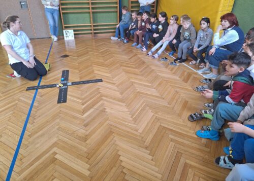 Die Schüler wiederholen mit einer Dame im Turnsaal das richtige Überqueren einer Straße.