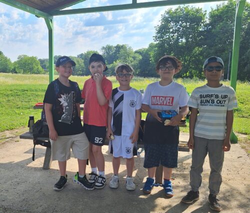5 Jungs stehen am Spielplatz beisammen