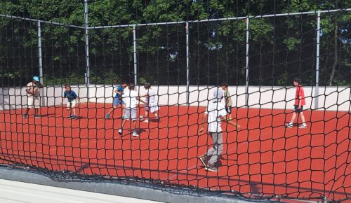 Kinder spielen am Hartplatz Fußball