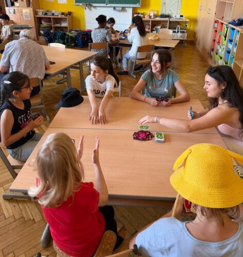 Kinder sitzen beim Tisch und spielen Gesellschaftsspiele