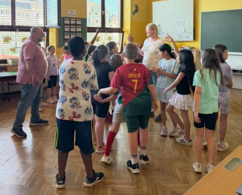 Kinder stehen in der Klasse im Kreis bei Gemeinschaftsspielen