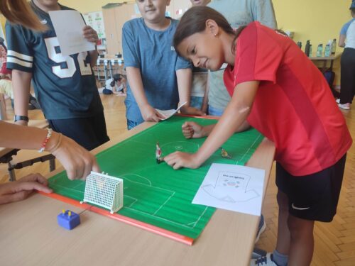 Kinder spielen am Tisch mit einem Tischkicker