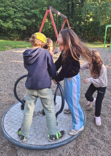 Kinder stehen auf einem Ringelspiel