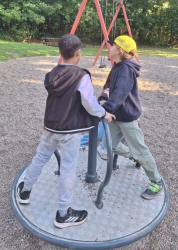 Kinder stehen auf einem Ringelspiel