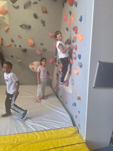 Kinder klettern auf einer Kletterwand