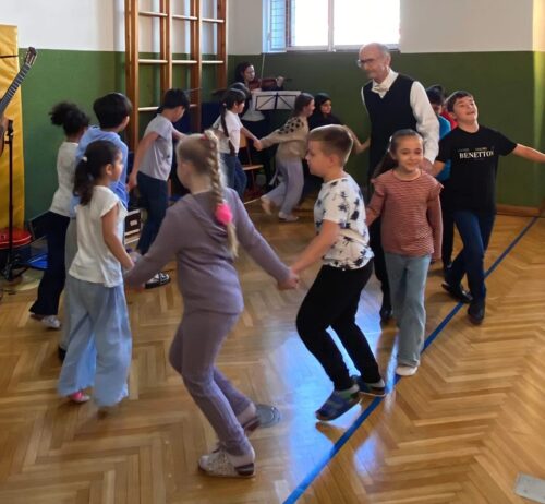 Die Kinder tanzen mit einem Mann im Kreis