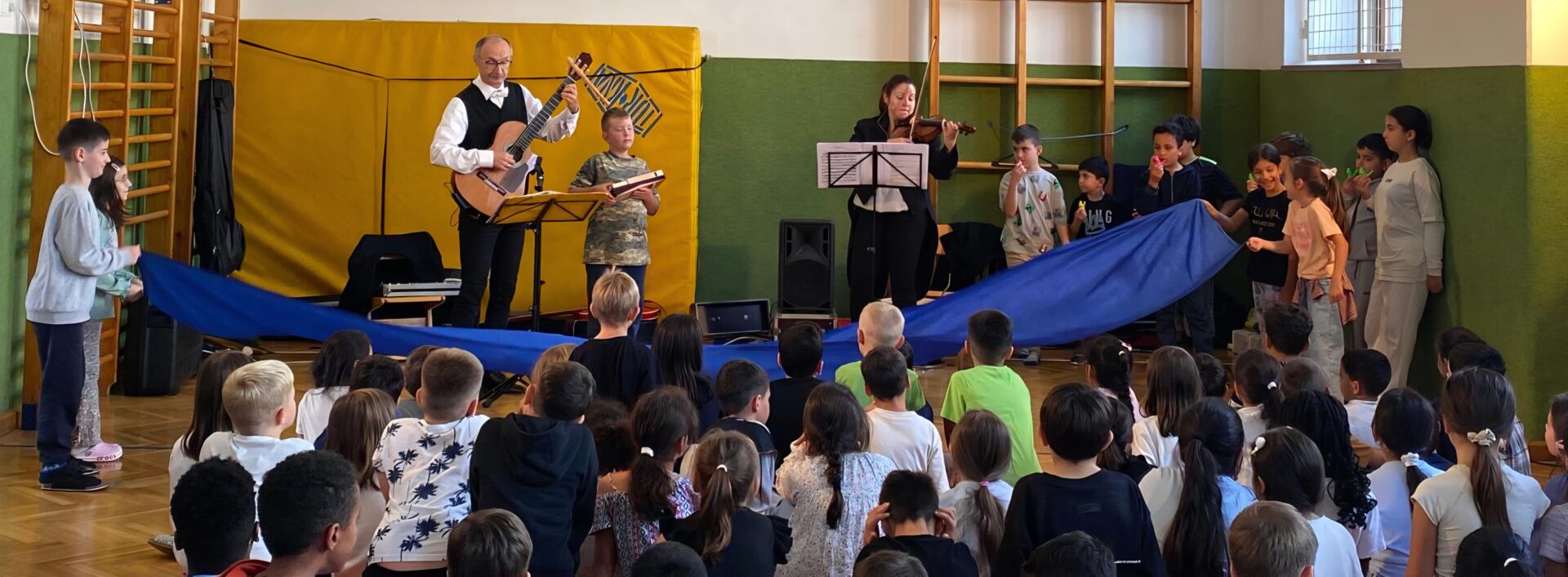 Die Kinder bewegen ein blaues Tuch zu einem Musikstück von Beethoven