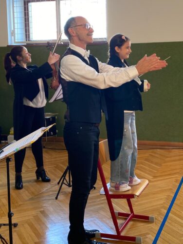 Der Mann und die Frau applaudieren dem dirigierendem Mädchen