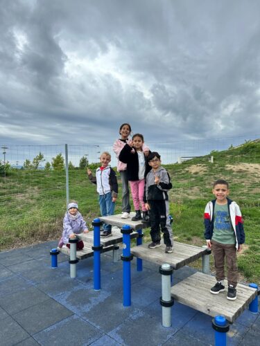 Kinder stehen gemeinsam auf einem Spielgerät