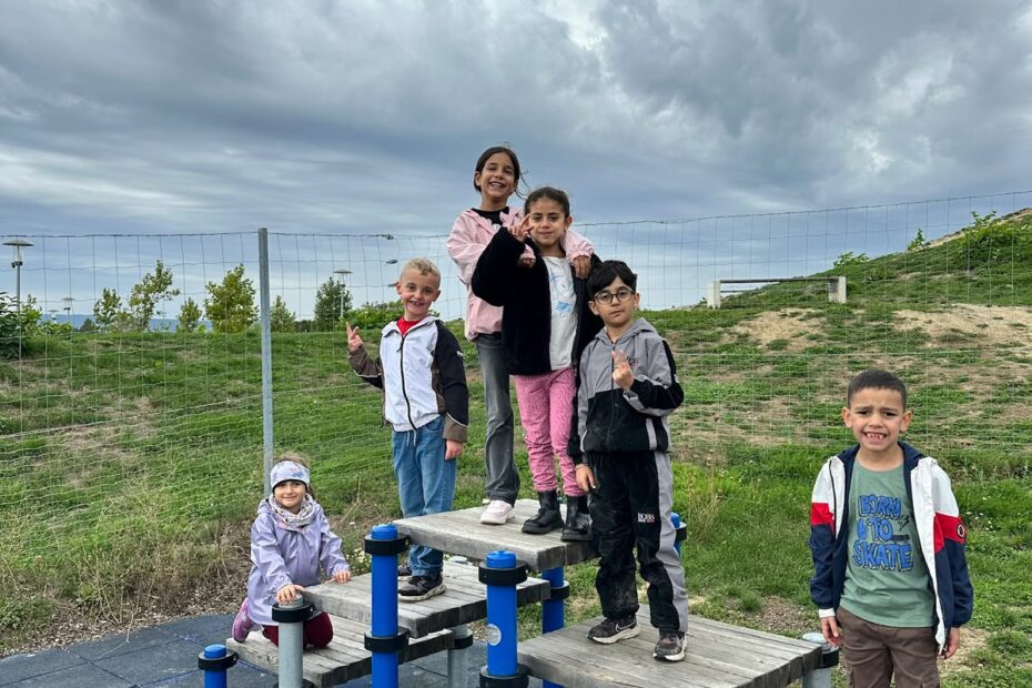 Kinder stehen gemeinsam auf einem Spielgerät
