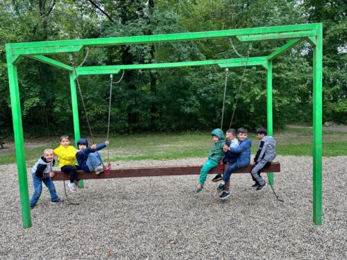 Kinder sitzen auf einem Spielgerät