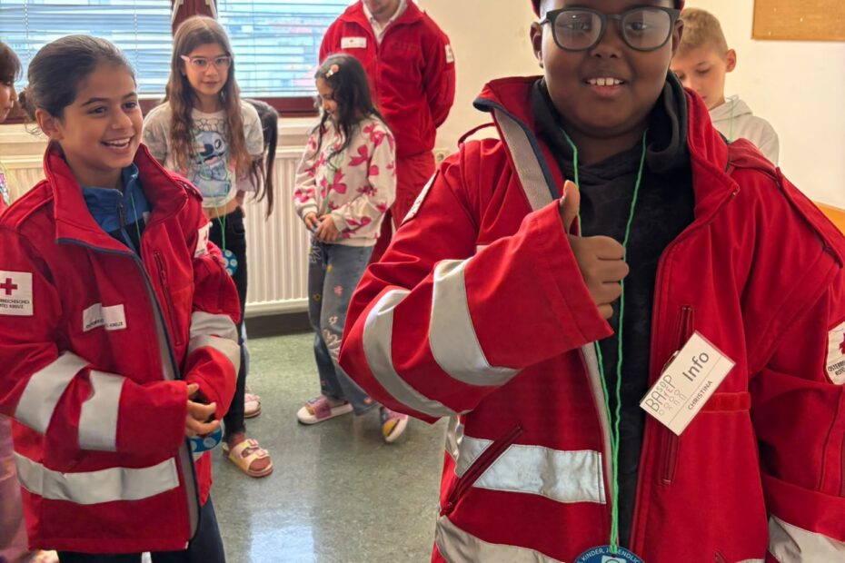 2 Kinder tragen zu große Jacken von Rettungssanitätern